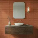 3D geometric Ecoblend Carmine Glossy Patterned 10mm tiles used as a warm terracotta accent wall in a modern lounge featuring a sleek wooden chair.